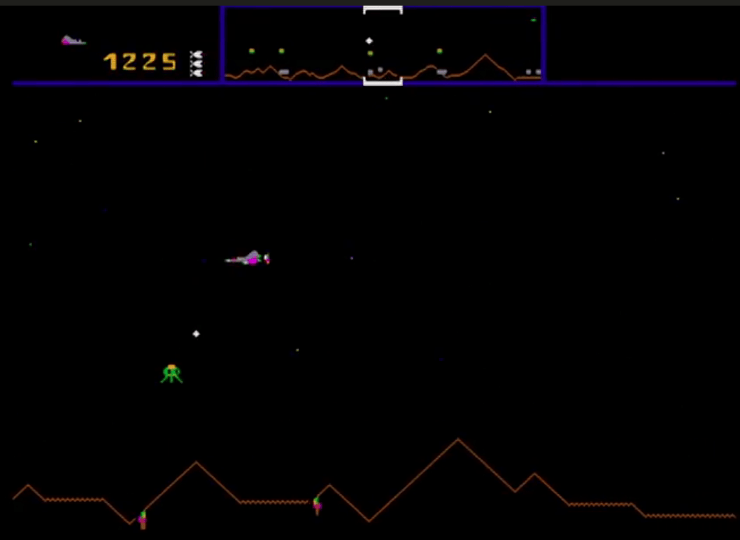 Defender in play, animated: the score band and scanner across the top, the ship flying and firing, a Lander rising with a humanoid, and the mountain terrain scrolling along the foot of the screen